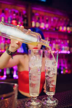 kadın barmen. mavi saçlı kız. gece barda kokteyl yapımı