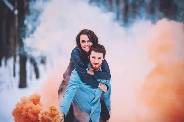 Hiver et rendez-vous. Jeune couple amoureux de l'homme et de la femme en hiver sur fond d'arbres enneigés dans le parc sont embrasser. Un gars avec les cheveux longs et la barbe garde les patins et aime petite amie . — Photo