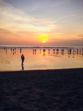 insanlar kum plajındaki günbatımı arka plan üzerinde