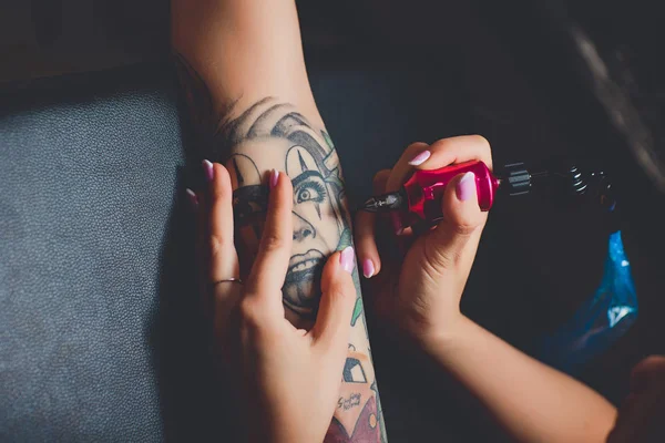 Kız dövme sanatçısı siyah bir tabloda onun el, pembe daktilo dövmesini yapıyor. — Stok fotoğraf