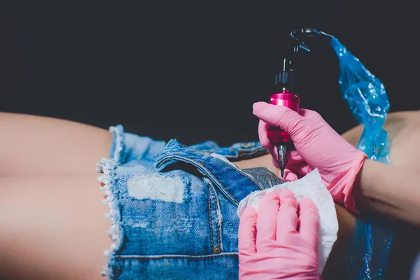 タトゥー アーティスト 彼女の腹 ピンクのタイプライターに入れ墨 ピンクの手袋 白い背景のスペシャ リスト — ストック写真