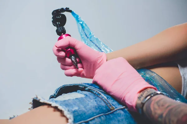 タトゥー アーティスト、彼女の腹、ピンクのタイプライターに入れ墨、ピンクの手袋、白い背景のスペシャ リスト. — ストック写真