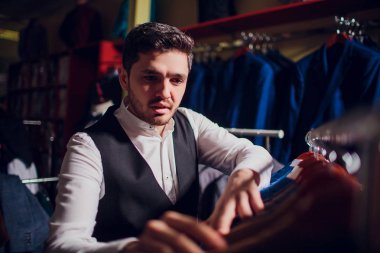 Terzi, terzilik. Erkek takım elbise, terzi atölyesinde. Elegant satırda asılı takım elbise mans. Lüks erkek klasik zarif mens butik rafa uygun.