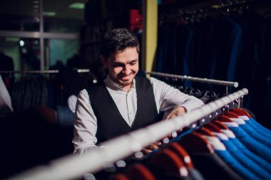 Terzi, terzilik. Erkek takım elbise, terzi atölyesinde. Elegant satırda asılı takım elbise mans. Lüks erkek klasik zarif mens butik rafa uygun.