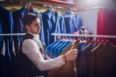 Terzi, terzilik. Erkek takım elbise, terzi atölyesinde. Elegant satırda asılı takım elbise mans. Lüks erkek klasik zarif mens butik rafa uygun.