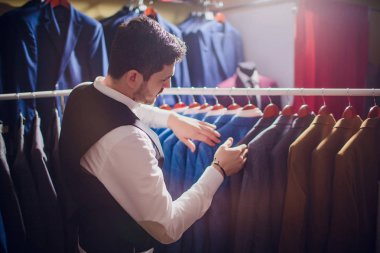 Terzi, terzilik. Erkek takım elbise, terzi atölyesinde. Elegant satırda asılı takım elbise mans. Lüks erkek klasik zarif mens butik rafa uygun.