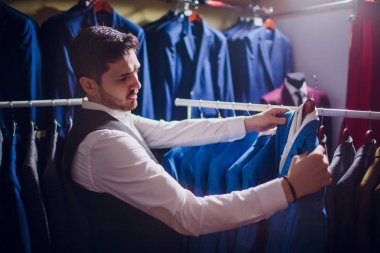 Terzi, terzilik. Erkek takım elbise, terzi atölyesinde. Elegant satırda asılı takım elbise mans. Lüks erkek klasik zarif mens butik rafa uygun.