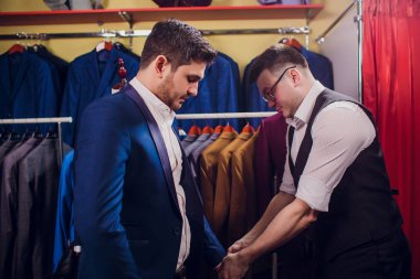 adam deposundaki takım elbise satın alıyor