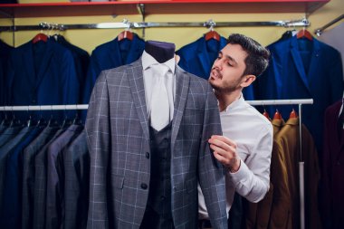 Terzi, terzilik. Erkek takım elbise, terzi atölyesinde. Elegant satırda asılı takım elbise mans. Lüks erkek klasik zarif mens butik rafa uygun.