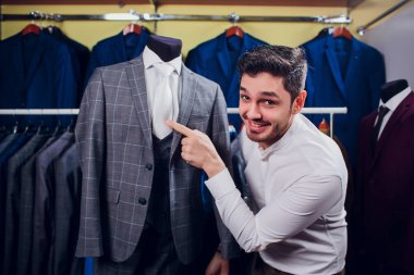 Terzi, terzilik. Erkek takım elbise, terzi atölyesinde. Elegant satırda asılı takım elbise mans. Lüks erkek klasik zarif mens butik rafa uygun.