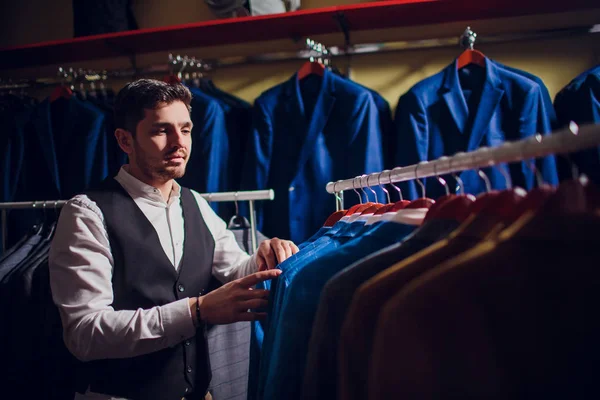 Terzi, terzilik. Erkek takım elbise, terzi atölyesinde. Elegant satırda asılı takım elbise mans. Lüks erkek klasik zarif mens butik rafa uygun.