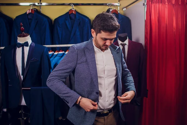 Terzi, terzilik. Erkek takım elbise, terzi atölyesinde. Elegant satırda asılı takım elbise mans. Lüks erkek klasik zarif mens butik rafa uygun.