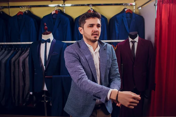 Tailleur, tailleur. Costume homme, tailleur dans son atelier. Des costumes d'hommes élégants suspendus en rang. Costumes classiques hommes de luxe sur rack dans une élégante boutique pour hommes . — Photo