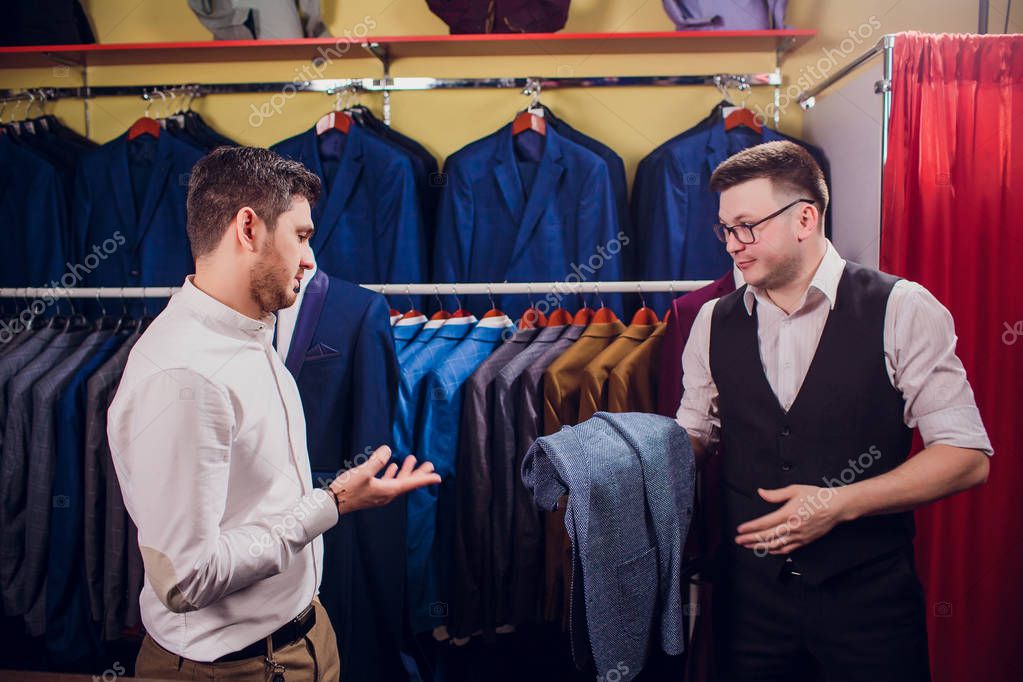 Uomo d'affari in giubbotto classico contro abiti da fila in