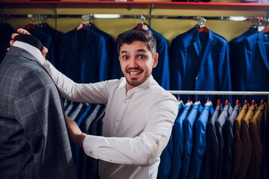 Terzi, terzilik. Erkek takım elbise, terzi atölyesinde. Elegant satırda asılı takım elbise mans. Lüks erkek klasik zarif mens butik rafa uygun.