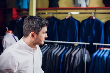 Terzi, terzilik. Erkek takım elbise, terzi atölyesinde. Elegant satırda asılı takım elbise mans. Lüks erkek klasik zarif mens butik rafa uygun.
