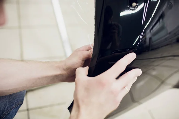 Pracovní ruce nainstaluje auto paint ochrana film zábal nárazníku — Stock fotografie
