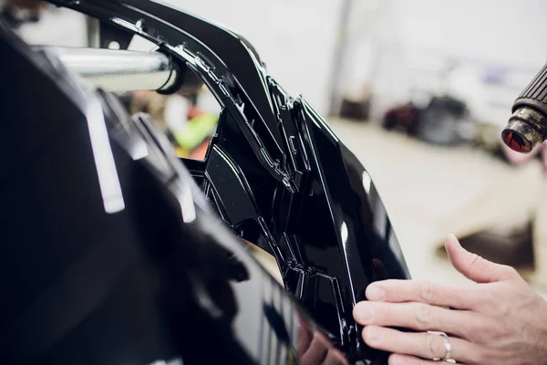 Robotnik ręce instaluje samochód farby ochrony film wrap zderzak — Zdjęcie stockowe
