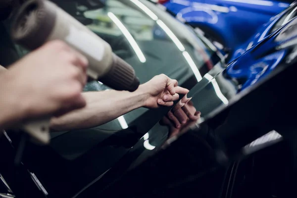 Trabajador manos instala coche pintura protección película envoltura capucha — Foto de Stock