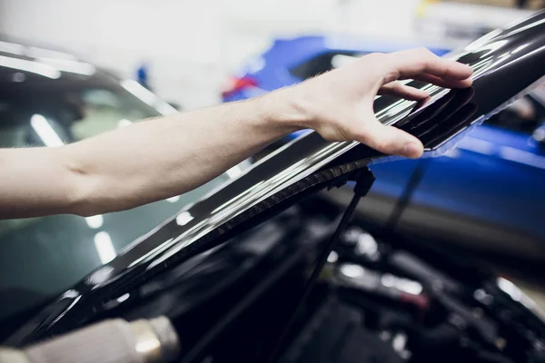 Trabajador manos instala coche pintura protección película envoltura capucha — Foto de Stock