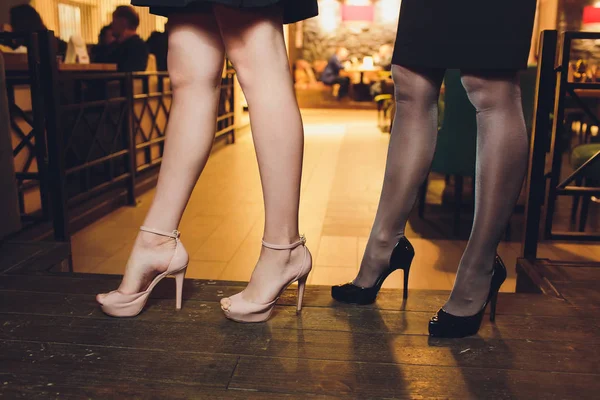 Primer plano de las piernas de las mujeres jóvenes en zapatos negros de tacón alto aislados . — Foto de Stock