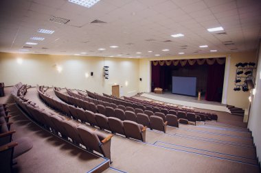 Konferans toplantı salonu Led ışıklar, satır kahverengi koltukları, sahne ve iş toplantı, konferans, eğitim kursu, boş ekran tavan ile kullanılan şablonu zarif tasarım ofisi