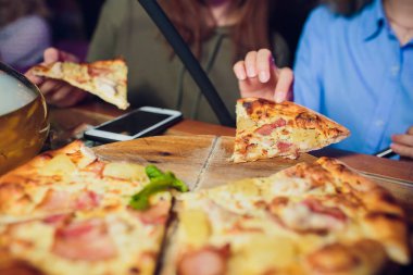 Dilim Pizza Margherita alarak elleriyle. Pizza Margarita ve elleri siyah arka plan üzerinde kapat.