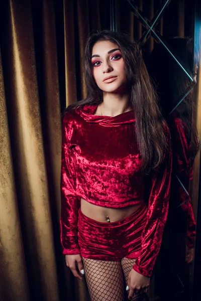 Modelo feminino bonita posando no fundo vermelho — Fotografia de Stock