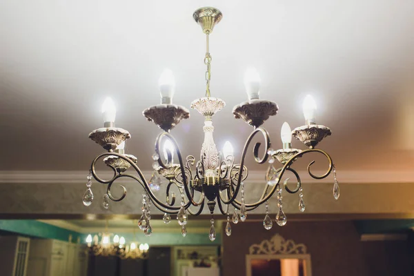 Lustre au plafond avec décorations classiques et lumières allumées dans six lampes . — Photo