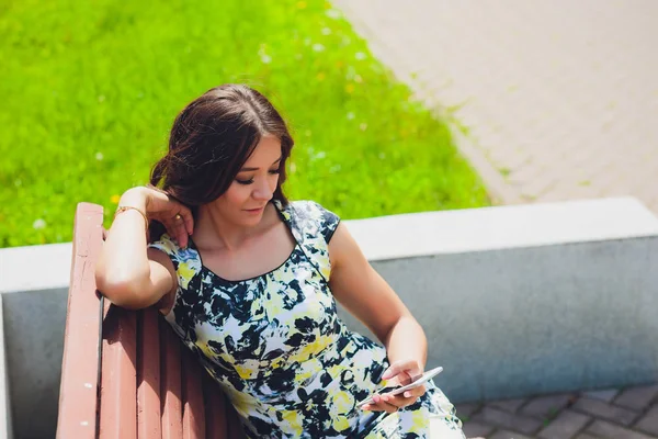 Bonita mulher sorridente com telefone celular andando na rua — Fotografia de Stock