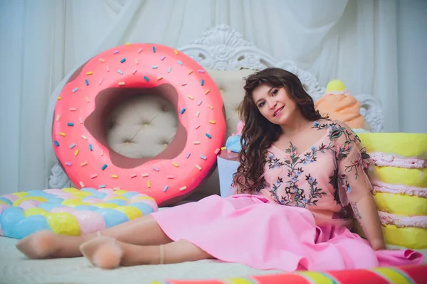 Jolie fille posant avec des beignets roses, s'amuser autour, dessert, mauvaise nourriture, regarde dans le trou dans le beignet, garde les beignets par les yeux — Photo