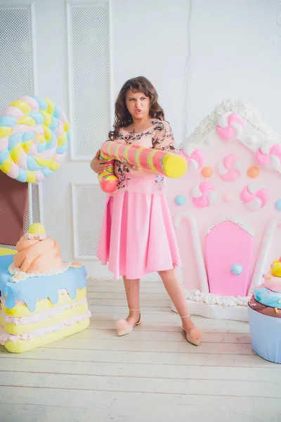 Söt flicka som poserar med rosa donuts, fipplat, dessert, dålig mat, ser i hålet i donut, håller munkar genom ögonen — Stockfoto