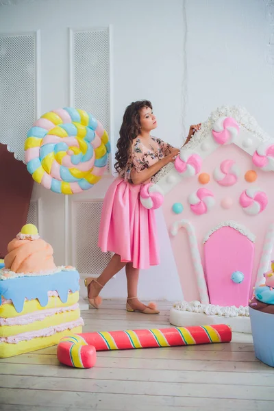 Ragazza carina in posa con ciambelle rosa, scherzare, dessert, cibo cattivo, guarda nel buco nella ciambella, tiene ciambelle per gli occhi — Foto Stock