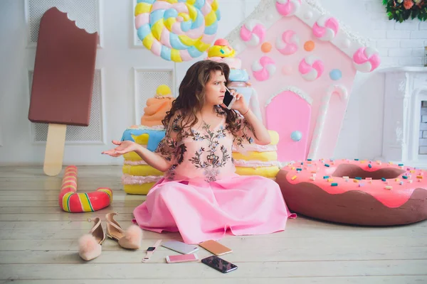 Bonito menina posando com rosa donuts, brincando, sobremesa, comida ruim, olha para o buraco no donut, mantém donuts pelos olhos — Fotografia de Stock