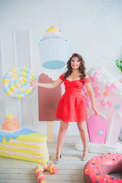 Bonito menina posando com rosa donuts, brincando, sobremesa, comida ruim, olha para o buraco no donut, mantém donuts pelos olhos — Fotografia de Stock