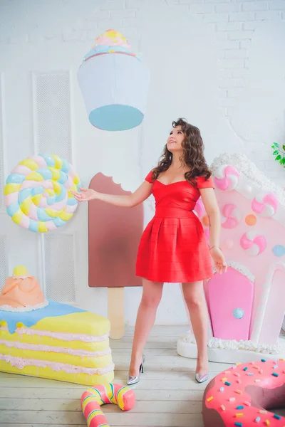 Bonito menina posando com rosa donuts, brincando, sobremesa, comida ruim, olha para o buraco no donut, mantém donuts pelos olhos — Fotografia de Stock