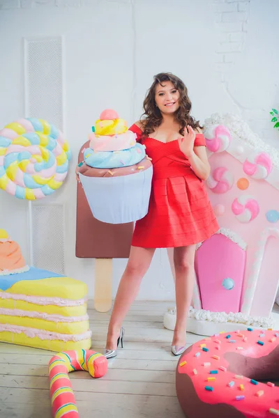 Bonito menina posando com rosa donuts, brincando, sobremesa, comida ruim, olha para o buraco no donut, mantém donuts pelos olhos — Fotografia de Stock