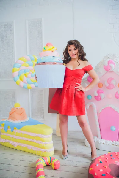 Bonito menina posando com rosa donuts, brincando, sobremesa, comida ruim, olha para o buraco no donut, mantém donuts pelos olhos — Fotografia de Stock