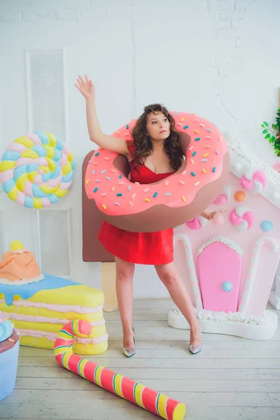 Bonito menina posando com rosa donuts, brincando, sobremesa, comida ruim, olha para o buraco no donut, mantém donuts pelos olhos — Fotografia de Stock