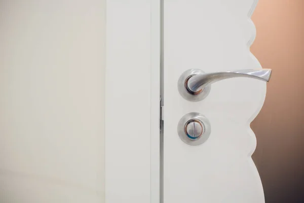Detalj av en metallisk knopp på vit dörr horisontell. — Stockfoto