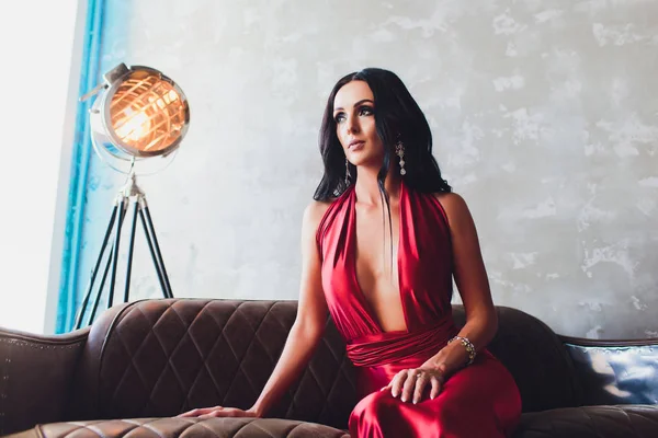 Μόδα στούντιο φωτογραφία πανέμορφη γυναίκα με σκούρα μαλλιά και βραδινό μακιγιάζ, πολυτελές κόκκινο φόρεμα φοράει. φώτα νέον τυρκουάζ ταινία προσκήνιο — Φωτογραφία Αρχείου