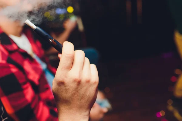 Tecnologia dei prodotti del tabacco non bruciati termicamente IQOS. Uomo che tiene la sigaretta elettronica in mano prima di fumare . — Foto Stock