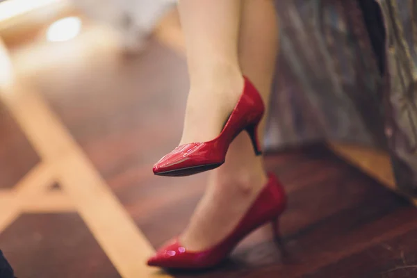 Close up cropped photo of beautiful legs of the business lady in high hills shoes. she is sitting in the office.