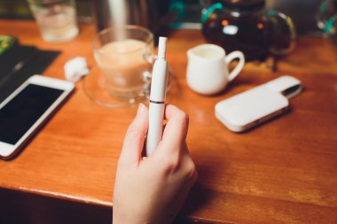Iqos ısı-değil-yanık tütün ürün teknolojisi. E-Sigara İçilmeyen önce elinde tutan kadın.