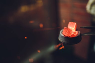 ocakta bir nargile barda koyu arka plan üzerinde kırmızı kömürü nargile için ısıtılan.