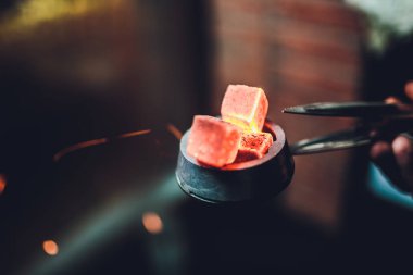 ocakta bir nargile barda koyu arka plan üzerinde kırmızı kömürü nargile için ısıtılan.