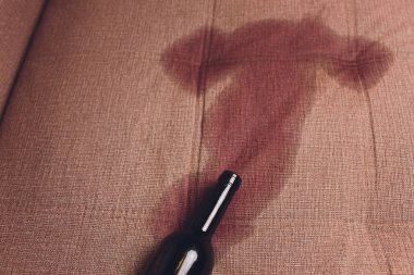 Kırmızı şarap kahverengi kanepe kanepede döktüm. koyu kırmızı şarap şişe düştü