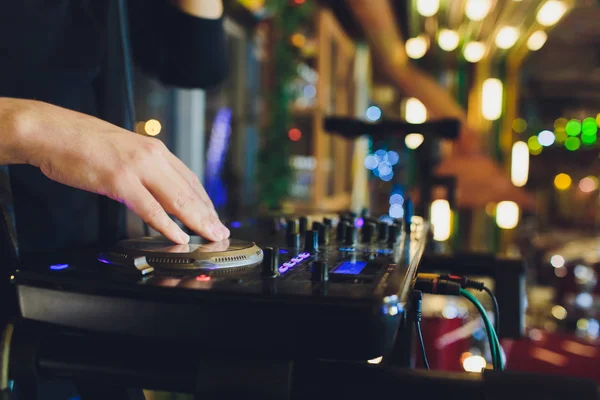 DJ tocando música en primer plano mezclador y mezcla la pista en el club nocturno en la fiesta . — Foto de Stock