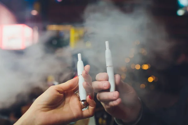 Tecnologia dei prodotti del tabacco non bruciati termicamente IQOS. Uomo che tiene la sigaretta elettronica in mano prima di fumare . — Foto Stock