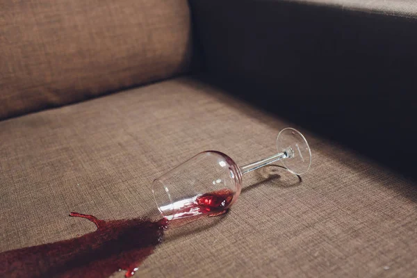 Rött vin spillda på en grå soffa soffa. — Stockfoto